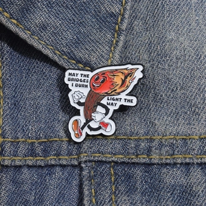 Detailansicht der Emaille-Anstecknadel auf Denim mit dem brennenden Streichholz
