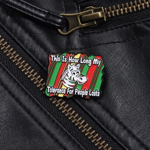 Detailed enamel pin with zebra design and humor quote on black leather jacket