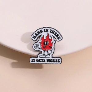 Cartoon fire enamel pin with Hang in there it gets worse text in retro comic style