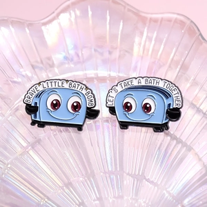Blue cartoon toaster enamel pins with funny slogans on rainbow shell tray background