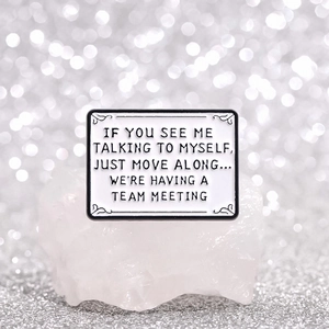Rectangle enamel brooch with humorous quote displayed on a crystal stone background