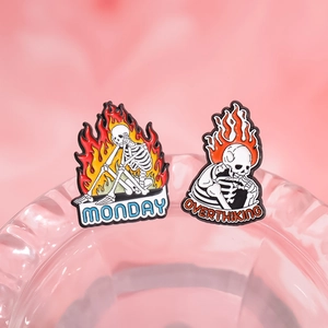 Cartoon flaming skull enamel pins featuring Monday and Overthinking text designs