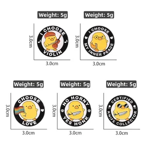 Detail view of five yellow cartoon duck enamel pins with musical and fun accessories