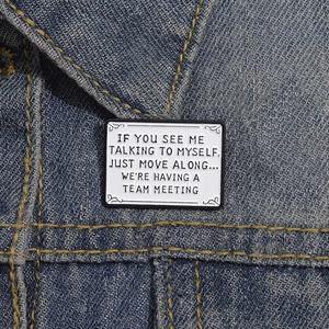Funny white enamel badge with humorous social quote on a blue denim jacket