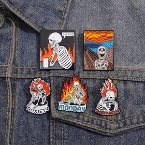 Set of five skull enamel pins featuring anxiety and art themes on denim background