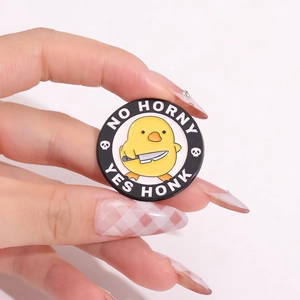 Cartoon yellow duck enamel pin badge with No Horny text and skull patterns on black base