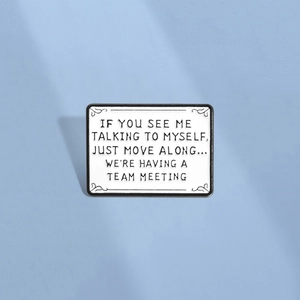 Minimalist white enamel rectangular brooch with black quote lettering and ornate edges