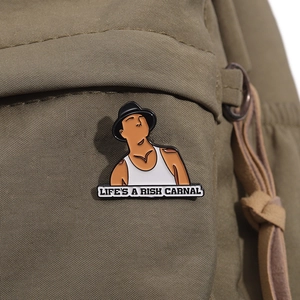 Creative punk metal brooch featuring cartoon man and LIFE'S A RISK CARNAL text on backpack