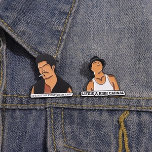 Detail of creative enamel pins with movie quotes pinned on a blue denim jacket collar