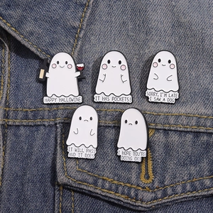 Detailansicht von fünf Emaille-Pins mit Geistern und Text auf blauem Denim-Hintergrund