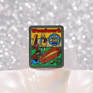 Retro enamel pin with 'Woodwork FOR Kids' illustration on silver bokeh background