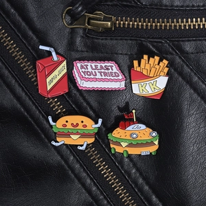 Set of cartoon enamel pins with cake and burger designs on a black leather jacket