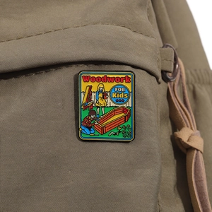 Détail du pin's émaillé Woodwork FOR Kids avec scène de cercueil rétro sur sac à dos marron