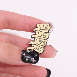 Geometric spine enamel brooch with 'I'VE GOT YOUR BACK' pun in light beige finish
