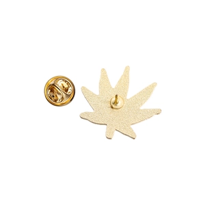 Detail of leaf-shaped alloy badge back with butterfly clasp and matte gold finish