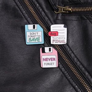 Close-up of retro floppy disk and document enamel pins on a black leather jacket texture