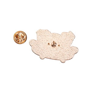 Macro shot of rose gold metal badge back with butterfly clutch and textured finish