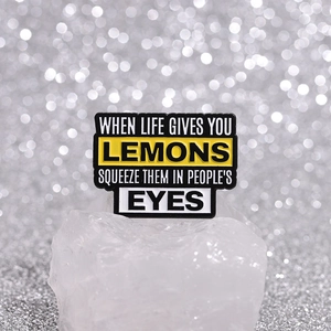Broche en émail avec citation citron sur cristaux blancs et fond à effet bokeh doux
