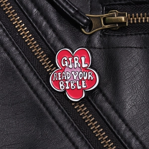 Close-up of red flower enamel badge with white text on a black leather jacket lapel