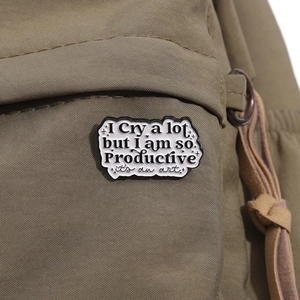 Emaille-Anstecknadel in Wolkenform mit Spruch auf braunem Leinwandrucksack