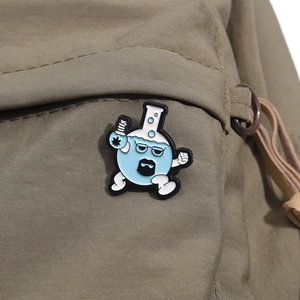 Close-up of a creative cartoon flask enamel pin with glasses on a green canvas bag