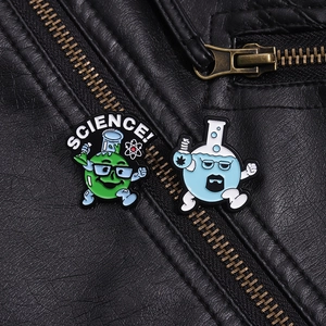 Close-up of science chemistry enamel pins worn on a black leather jacket collar