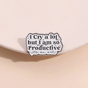 Schwarz-weiße Brosche mit I Cry a lot Spruch auf einer dekorativen Keramikschale