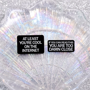 Black enamel brooch set with witty English text on stylish silver glitter background