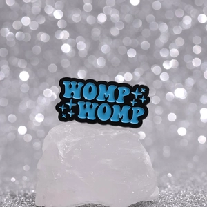 Mini broche en émail noir WOMP WOMP avec lettrage bleu sur base de cristal