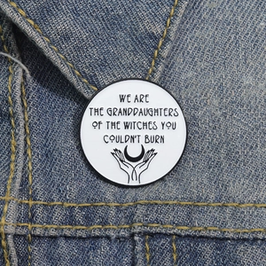 Detail of round Girl Power enamel pin on denim jacket showing feminist witch quote slogan