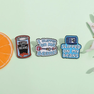 Three-piece I Slipped On My Beans enamel pin set with colorful tin can designs
