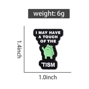 Detailed close-up of cartoon frog enamel pin with funny English text on white background