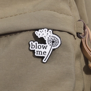 Kreative Emaille-Brosche Pusteblume mit Spruch Blow Me auf grünem Canvas-Stoff