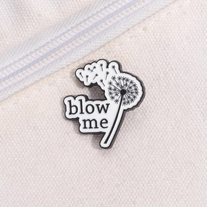 Makroansicht der Pusteblume-Emaille-Anstecknadel mit Blow me-Text auf Segeltuch