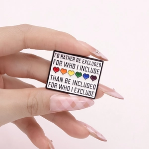 Square enamel brooch with rainbow hearts and inclusive quote held by hand