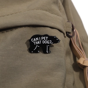 Schwarzer Bär Emaille-Pin mit Can I Pet That Dog Text auf olivgrünem Segeltuch-Rucksack