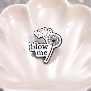 Spilla smaltata minimalista con dente di leone bianco e nero e scritta blow me