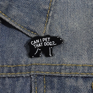 Lustige schwarze Bären-Emaille-Anstecknadel mit Spruch auf blauem Denim-Hintergrund