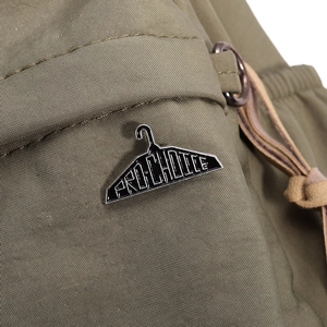 Detail of metal PRO-CHOICE hanger enamel pin pinned on olive green fabric garment