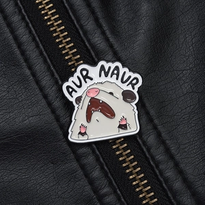 Détail de la broche émaillée opossum avec texte AUR NAUR sur une veste en cuir noir
