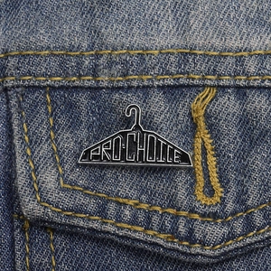Close-up of PRO-CHOICE enamel pin badge attached to a blue denim jacket pocket