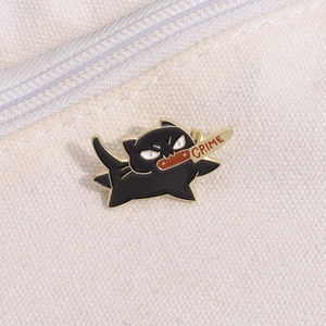 Detail of a funny black cat enamel pin with a gold dagger and Crime text on white canvas