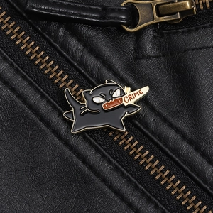 Detailed macro view of black enamel cat badge with crime knife on leather background