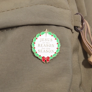 Détail de broche couronne de Noël avec texte Jesus is the reason for the season
