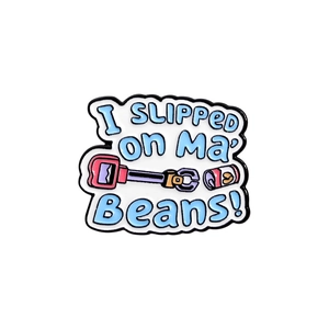 Detail view of light blue enamel pin featuring I SLIPPED on Ma BEANS text and cartoon graphics