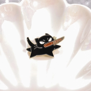 Creative black cat enamel pin with a crime knife held in its mouth on a shell tray