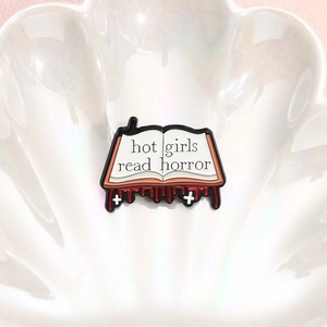 Enamel book brooch featuring Hot Girls Read Horror quote with red liquid detail