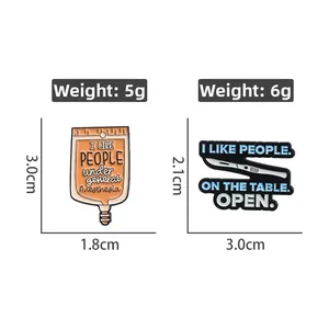 Detailed enamel pins featuring an orange IV bag and a blue scalpel with medical humor text