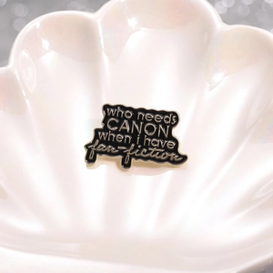 Broche fan-fiction en émail noir avec bordure dorée dans une coupelle en coquille