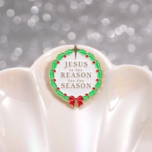 Broche couronne de Noël en émail avec message religieux sur un plateau en coquillage